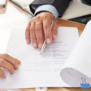 Close-up of business people examining business resume at the table during a job interview